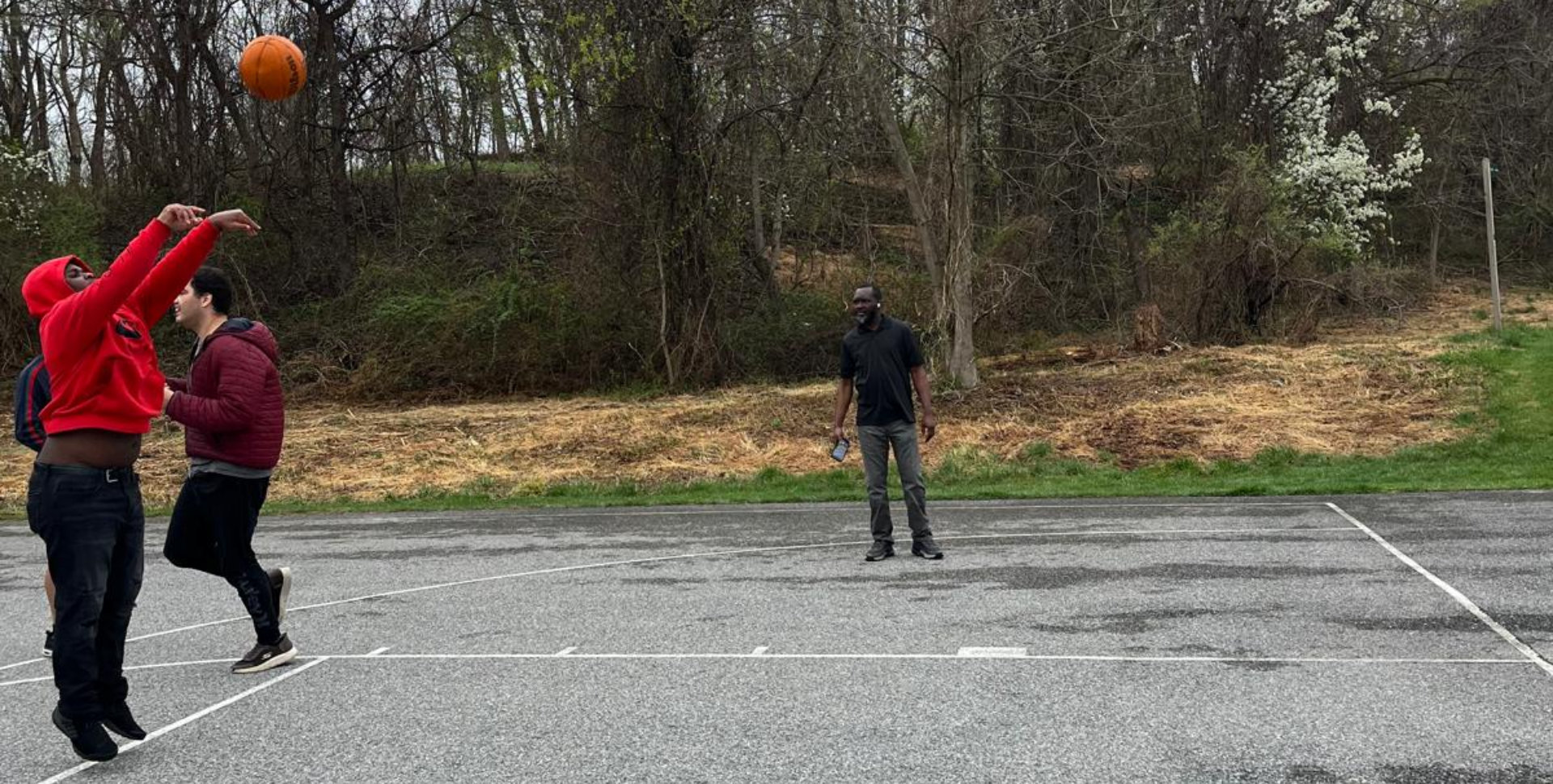 Men playing basketball outside
