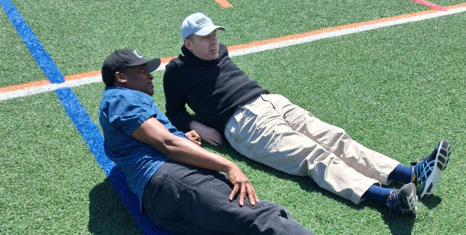 Men laying on field