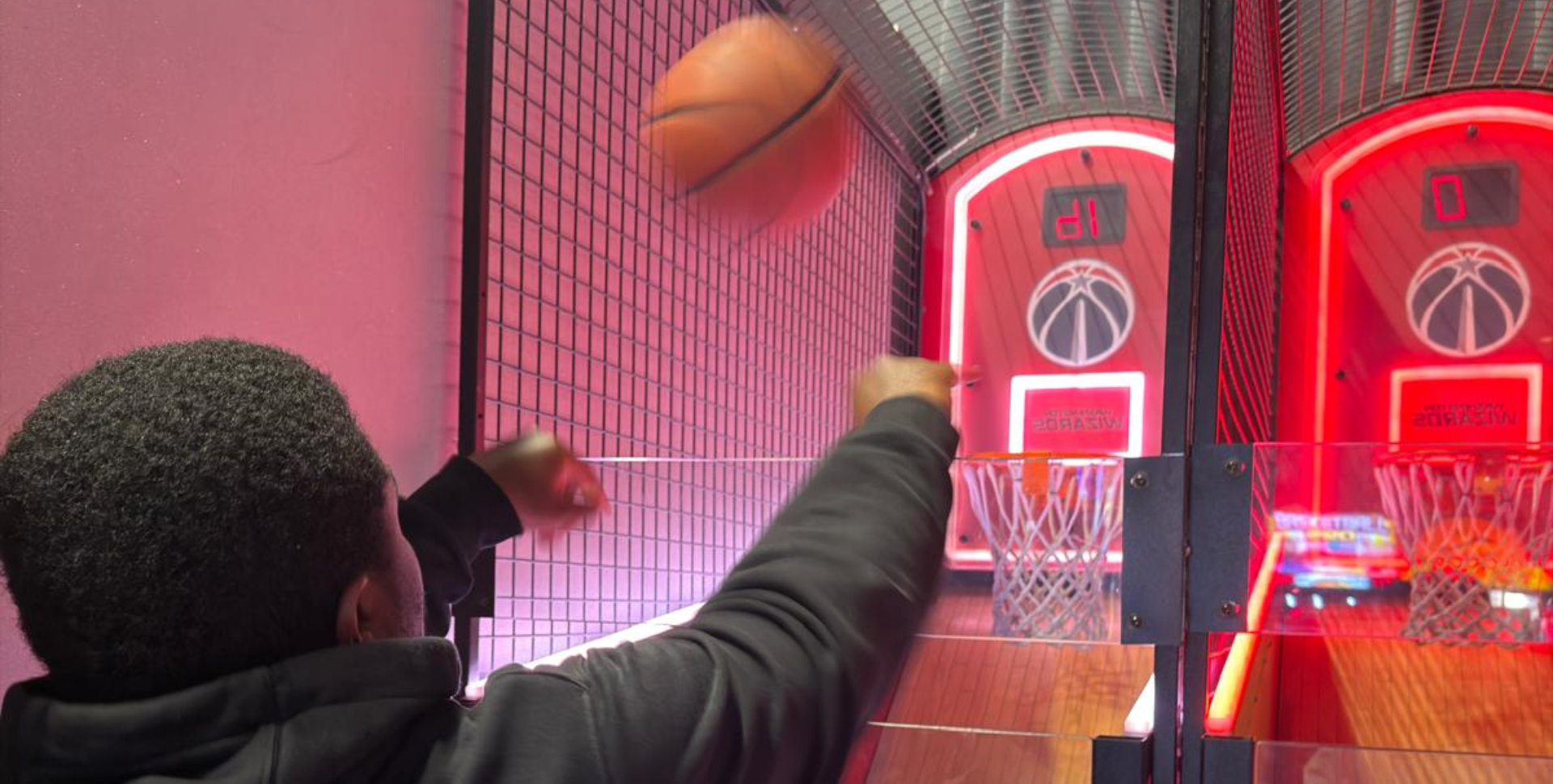 Man playing basketball shooting game in arcade
