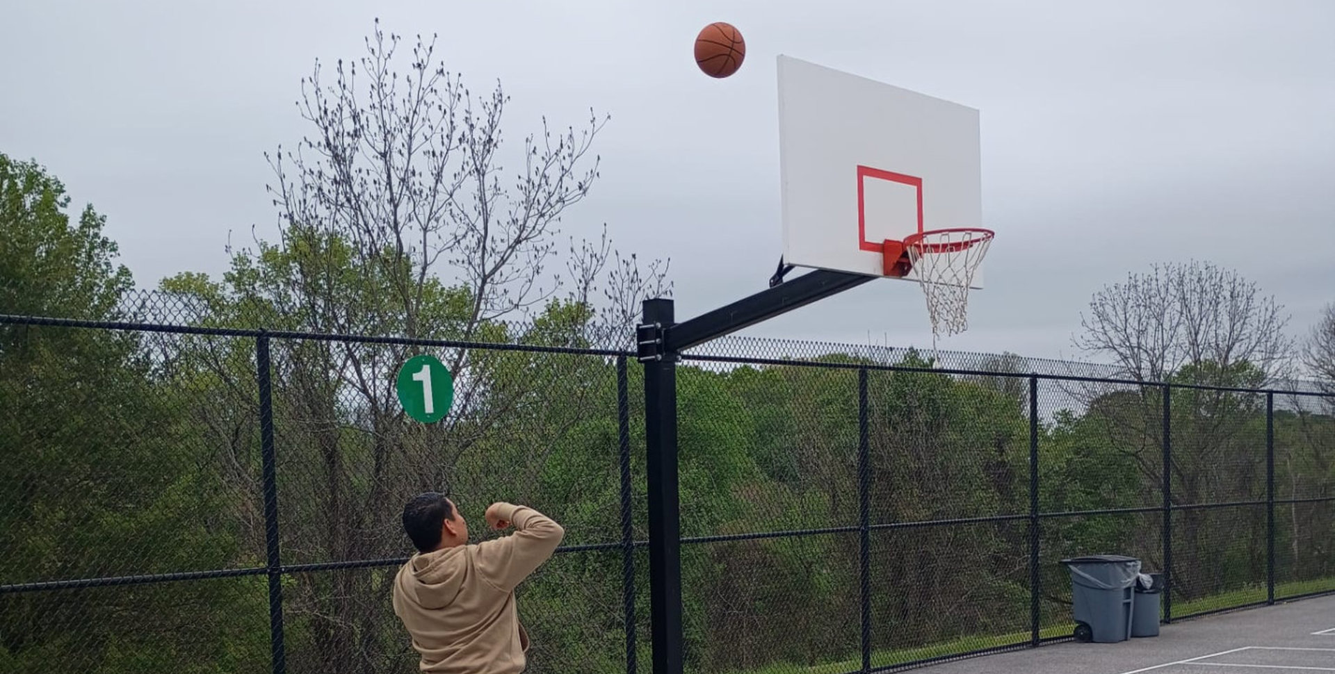 Man shooting a basketball outdoors