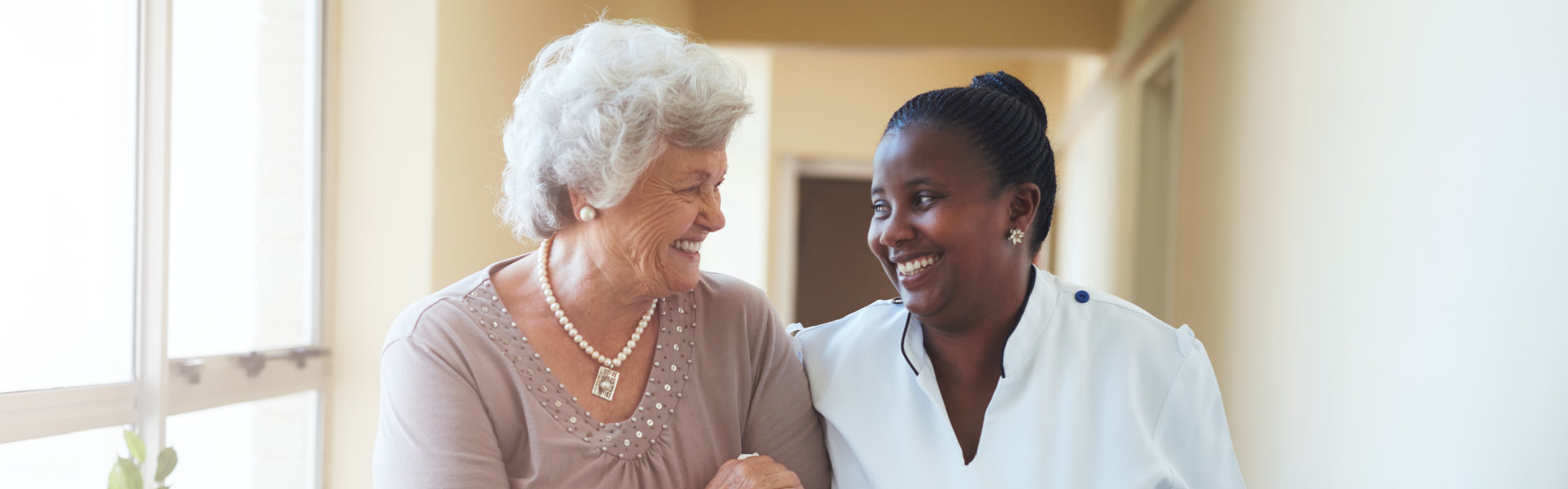 caregiver and elderly woman smiling